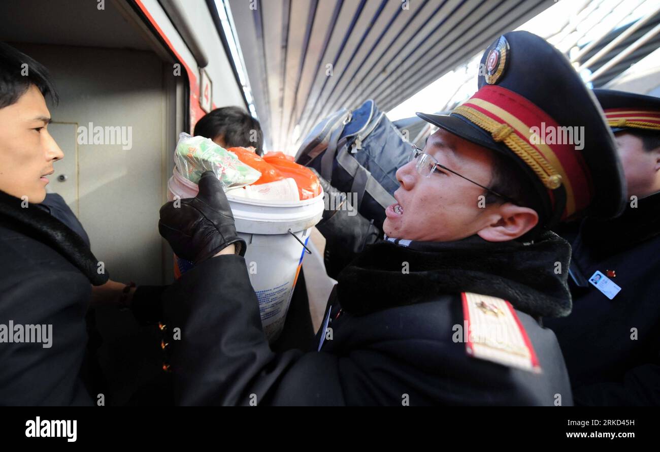 Bildnummer: 54858408  Datum: 27.01.2011  Copyright: imago/Xinhua (110127) -- BEIJING, Jan. 27, 2011 (Xinhua) -- Wang Le, a staff member of Beijing West Railway Station, helps passengers move their belongings aboard a train at the station in Beijing, capital of China, Jan. 25, 2011. Since China s 40-day period of Spring festival travel rush began on Jan. 19, all of the station s staff members have extended their labor time to more than 10 hours a day to ensure trains setting off and arriving on time with their passengers. The nationwide railway system transported 35, 886, 000 passengers from Ja Stock Photo