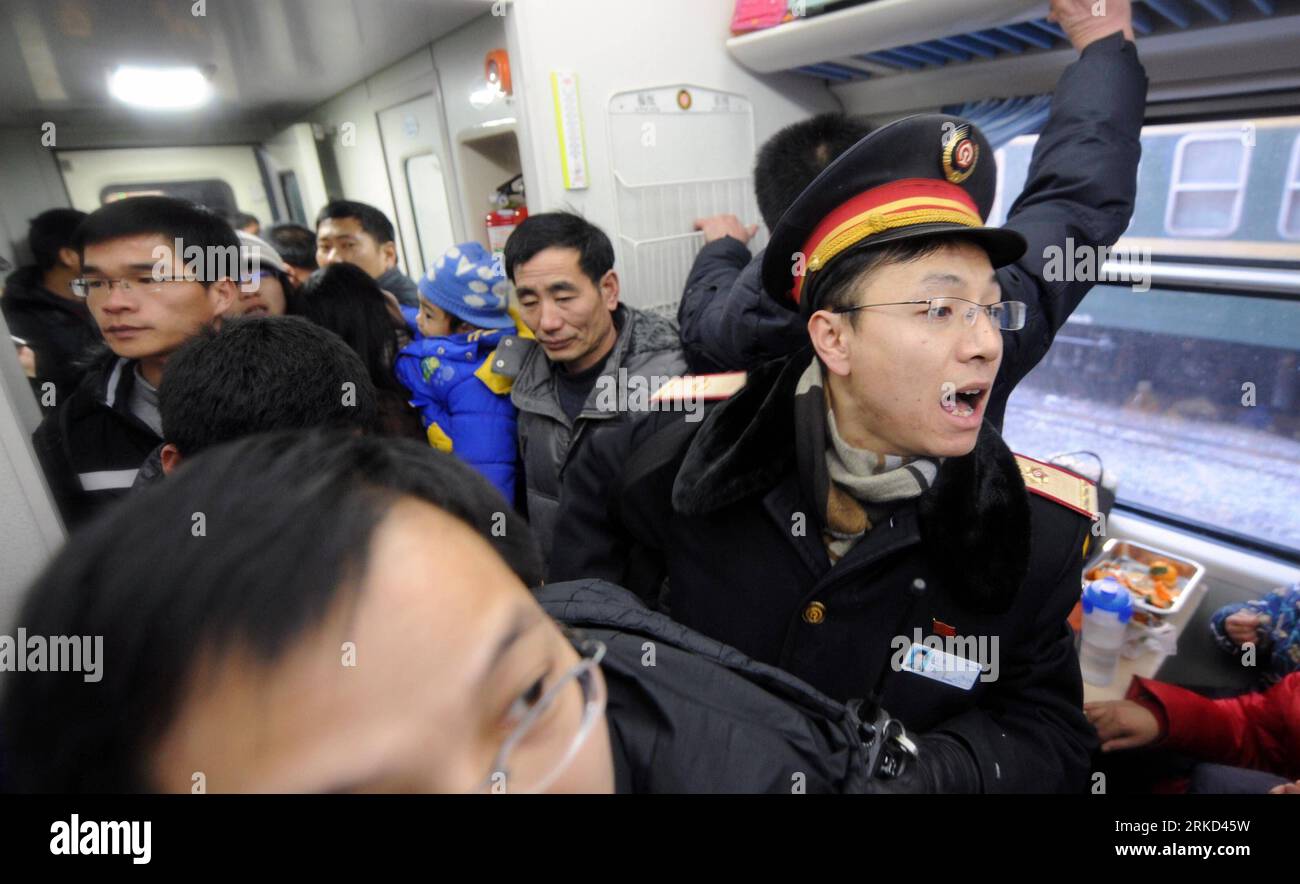 Bildnummer: 54858415  Datum: 27.01.2011  Copyright: imago/Xinhua (110127) -- BEIJING, Jan. 27, 2011 (Xinhua) -- Wang Le, a staff member of Beijing West Railway Station, helps passengers find their seats in a train at the station in Beijing, capital of China, Jan. 25, 2011. Since China s 40-day period of Spring festival travel rush began on Jan. 19, all of the station s staff members have extended their labor time to more than 10 hours a day to ensure trains setting off and arriving on time with their passengers. The nationwide railway system transported 35, 886, 000 passengers from Jan. 19 to Stock Photo