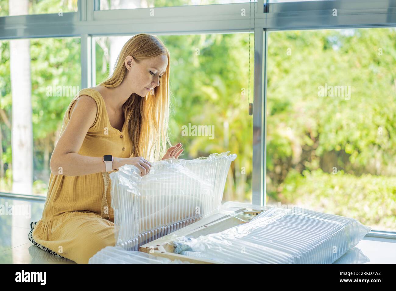 Pregnant woman unpacks and assembles baby furniture. young pregnant