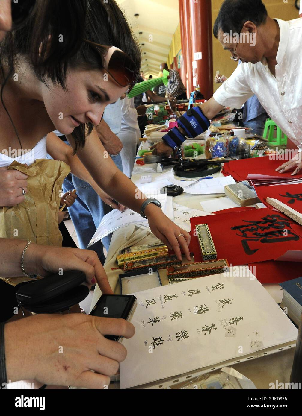 Bildnummer: 54884178  Datum: 06.02.2011  Copyright: imago/Xinhua (110206) -- PRETORIA, Feb. 6, 2011 (Xinhua) -- A South African woman watches Chinese letters at the Chinese New Year Culture Festival held by the Nan Hua Temple in Bronkhorstspruit, South Africa, Feb. 6, 2011. The Chinese New Year Culture Festival held on Sunday has attracted more than 15,000 overseas Chinese and local civilians to enjoy the Chinese culture including watching lion and dragon dances, receiving bonus, tasting Chinese tea and food. (Xinhua/Li Qihua) SOUTH AFRICA-CHINESE NEW YEAR CULTURE FESTIVAL PUBLICATIONxNOTxINxC Stock Photo