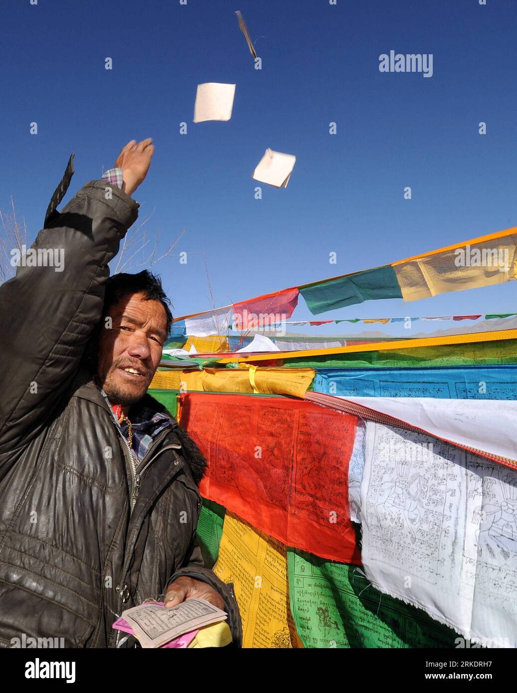 Bildnummer: 54990901  Datum: 07.03.2011  Copyright: imago/Xinhua (110307) -- LHASA, March 7, 2011 (Xinhua) -- A man throw small prayer flags into the air to pray for good luck in Lhasa, capital of southwest China s Tibet Autonomous Region, March 7, 2011, the third day of Tibetan New Year or Losar. Losar can be traced back to the pre-Buddhist period in Tibet when Tibetans practised the Bon religion. (Xinhua/Chogo) (lfj) CHINA-TIBET-LOSAR CELEBRATION (CN) PUBLICATIONxNOTxINxCHN Gesellschaft kbdig xub 2011 hoch o0 Tradition Neujahr  o0 Tradition Neujahr Gebetsfahnen   Gebetsflaggen   Gebetsfahne Stock Photo
