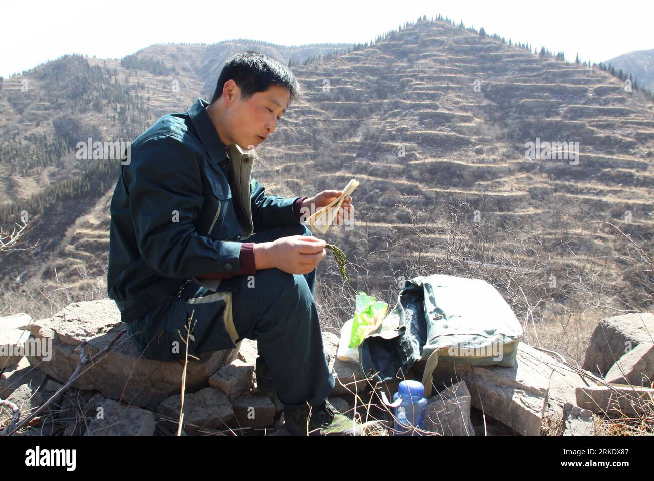 Bildnummer: 55014206  Datum: 09.03.2011  Copyright: imago/Xinhua (110311) -- QINGZHOU, March 11, 2011 (Xinhua) -- Postman Sun Jigang has lunch while delivering mails in Qingzhou, east China s Shandong Province, March 9, 2011. Sun walks on a 34-kilometer-long post path in the remote mountainous area every two days to deliver mails for 13 villages along the way. It has been five years since Sun started the job and he is the only postman serving on the path. (Xinhua/Sun Shubao) (hdt)  CHINA-SHANDONG-SUN JIGANG-POSTMAN (CN) PUBLICATIONxNOTxINxCHN Gesellschaft Arbeitswelten Post Briefträger CHN kur Stock Photo