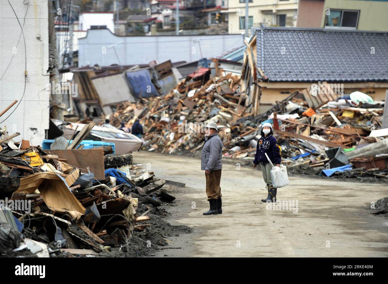 Bildnummer: 55049015  Datum: 21.03.2011  Copyright: imago/Xinhua (110321) -- MIYAGI-KEN, March 21, 2011 (Xinhua) -- Two walk among building debris in Kesennuma, Miyagi-ken in Japan, March 21, 2011. Japan s recent earthquake and tsunami would cause up to 235 billion U.S. dollars in damage and a temporary impact on the economic growth of Japan and the region, but the growth will pick up after mid-2011 as reconstruction efforts get underway, the World Bank said in a report on Monday. (Xinhua/Song Zhenping) (lmz) JAPAN-MIYAGI-KEN-QUAKE PUBLICATIONxNOTxINxCHN Gesellschaft Japan Naturkatastrophe Erd Stock Photo