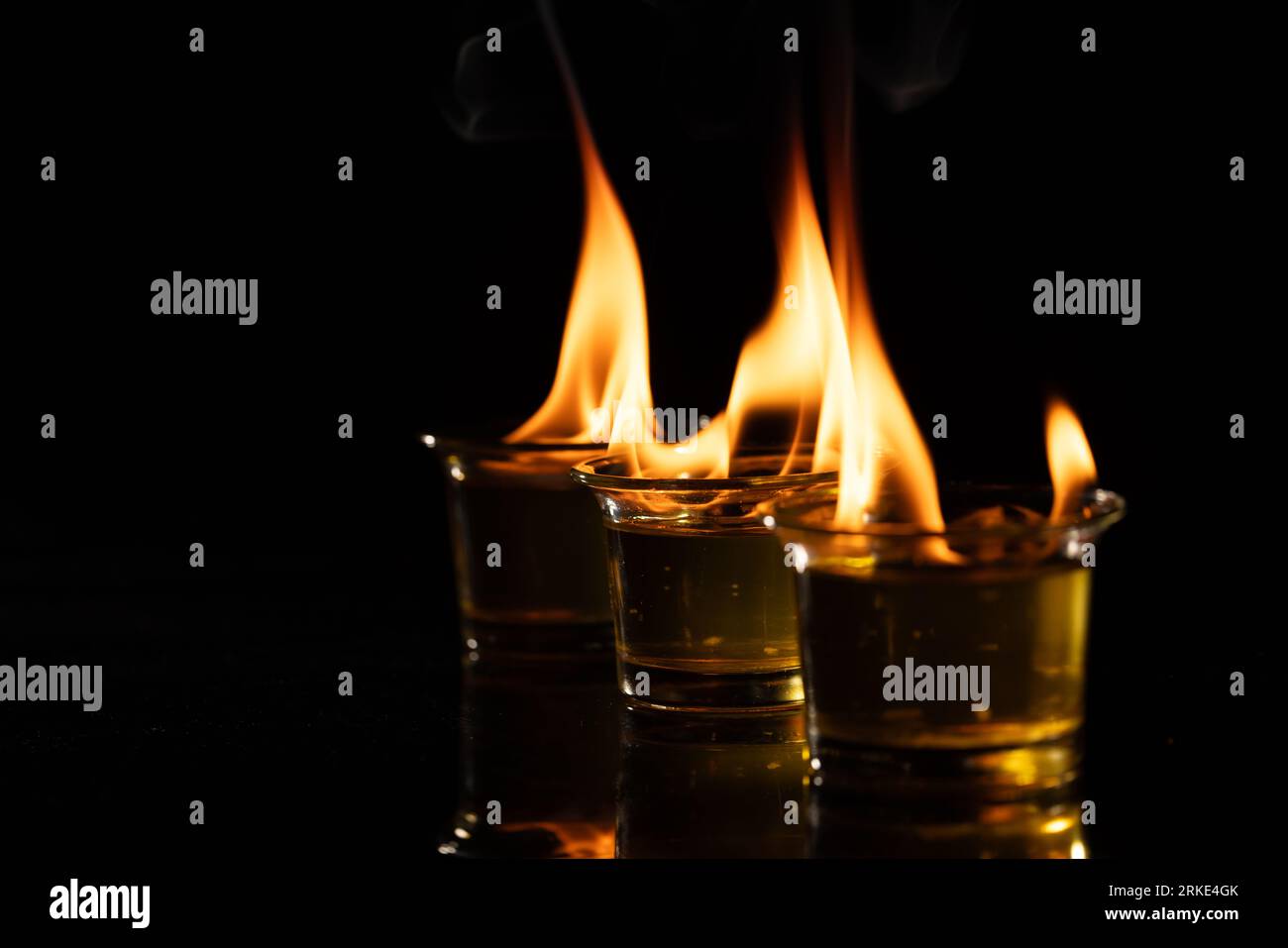 Three lit candles with copy space on black background Stock Photo