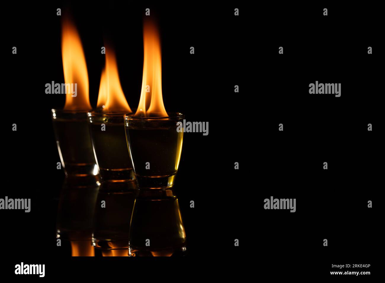 Three lit candles with copy space on black background Stock Photo