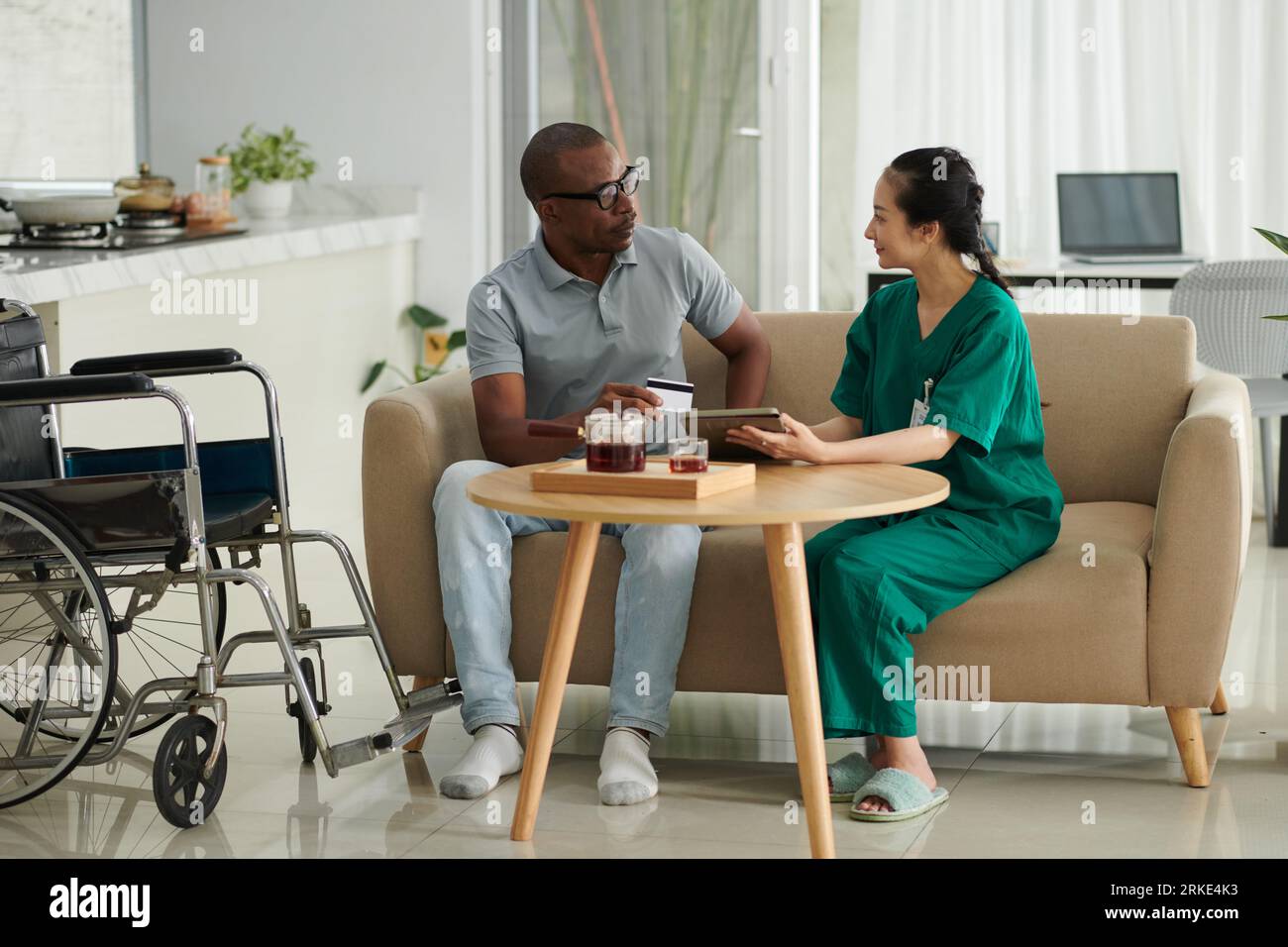 Black man with disability asking social worker to help with ordering