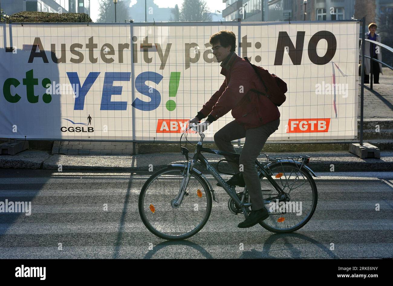 Bildnummer: 55061783  Datum: 24.03.2011  Copyright: imago/Xinhua (110324) -- BRUSSELS, March 24, 2011 (Xinhua) -- A bicyclist passes by a poster of the demonstration in Brussels, capital of Belgium on March 24, 2011. Some 20,000 marched here Thursday against austerity measures as European Union (EU) leaders were to begin a crucial summit to endorse a comprehensive response to the year-long debt crisis. (Xinhua/Wu Wei) (xhn) BELGIUM-BRUSSELS-EU-SUMMIT-DEMONSTRATION PUBLICATIONxNOTxINxCHN People Politik EU Gipfel Gipfeltreffen Demonstration premiumd kbdig xsp 2011 quer  o0 Sparmaßnahmen, Radfahr Stock Photo