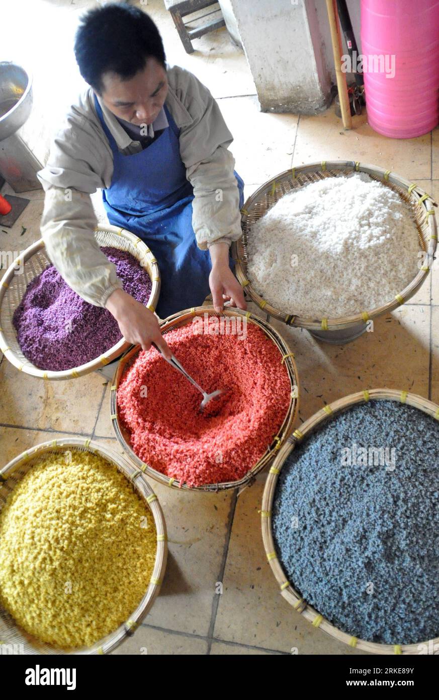 Bildnummer: 55114682  Datum: 28.03.2011  Copyright: imago/Xinhua (110328) -- NANNING, March 28, 2011 (Xinhua) -- A retailer makes five-color glutinous rice in Nanning, capital of southwest China s Guangxi Zhuang Autonomous Region, March 27, 2011. of Zhuang ethnic group have a tradition of making five-color glutinous rice during the Qingming Festival, also known as Tomb Sweeping Festival that falls on April 5 this year. Colored by steeped natural herbaceous plants such as day lily and maple leaf, the five-color rice, represents a good harvest of the year. (Xinhua/Lu Bo an) (wyo) #CHINA-GUANGXI- Stock Photo