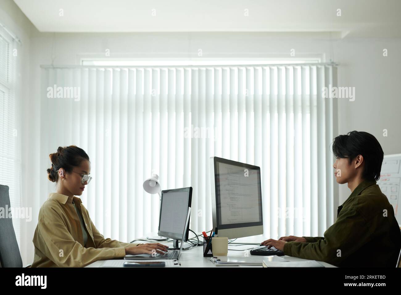 Software developers working on computers in modern office of it company Stock Photo