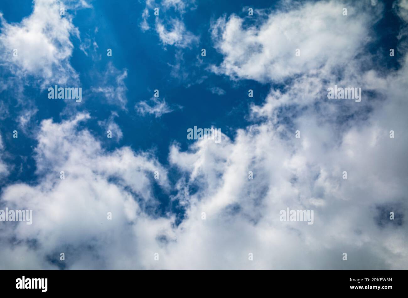 White stratocumulus clouds against a blue sky on a sunny day in southern England. Stock Photo