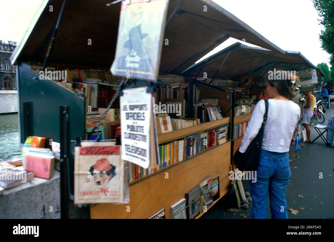 Paris France People Looking At Bouquiniste (Book Stall) on the Banks of the River Seine Stock Photo