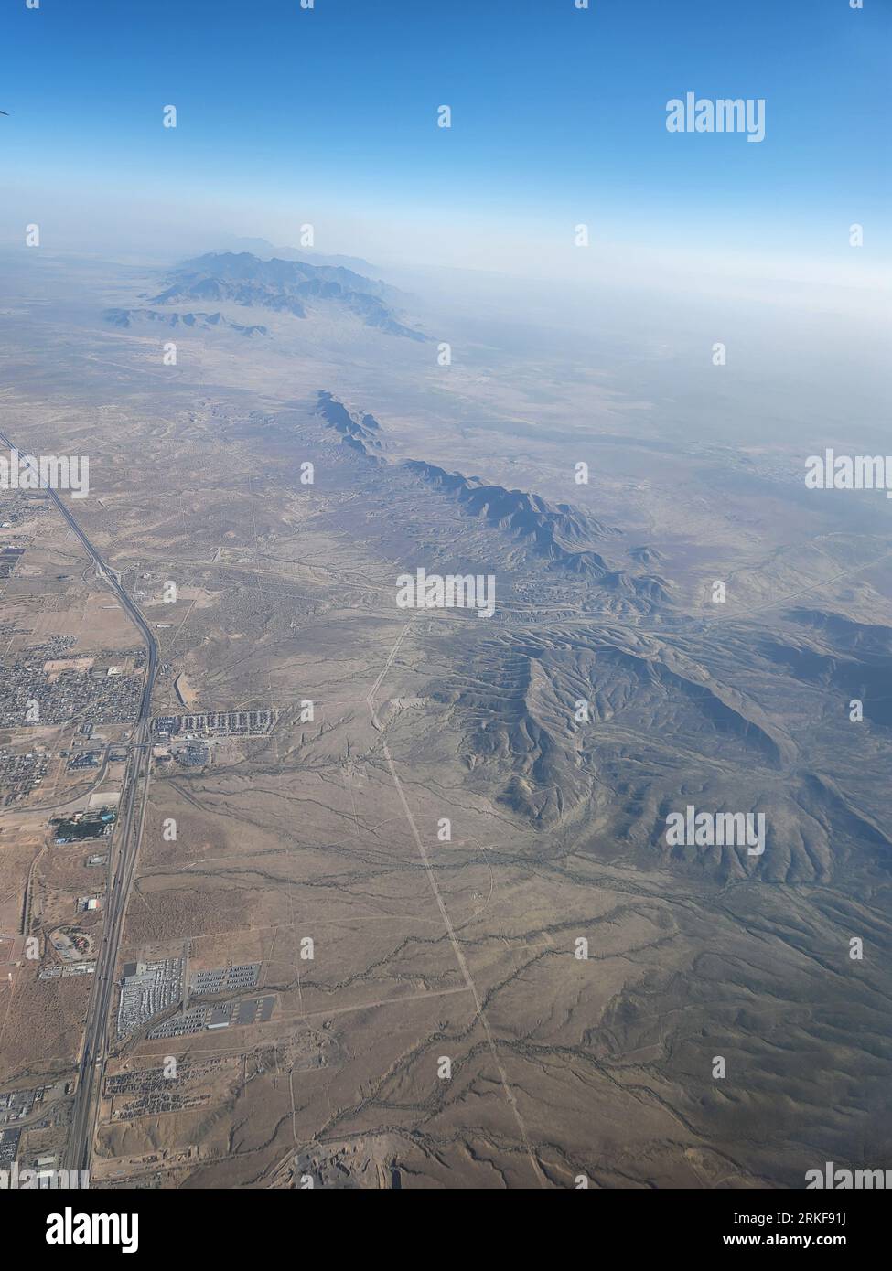 An aerial view of a vast desert landscape featuring rolling hills and