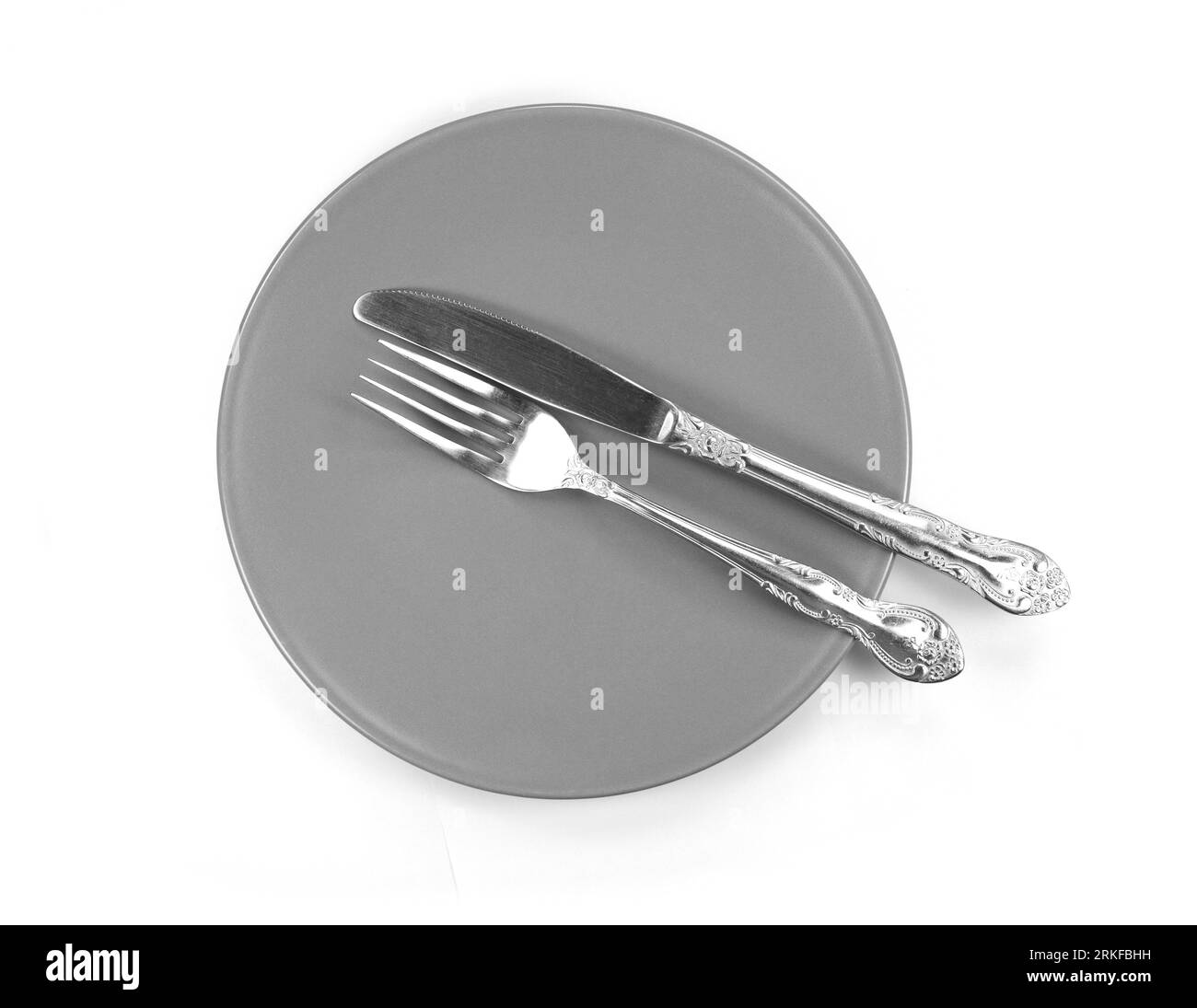 Empty plate with knife and fork. Top view, isolated on white Stock