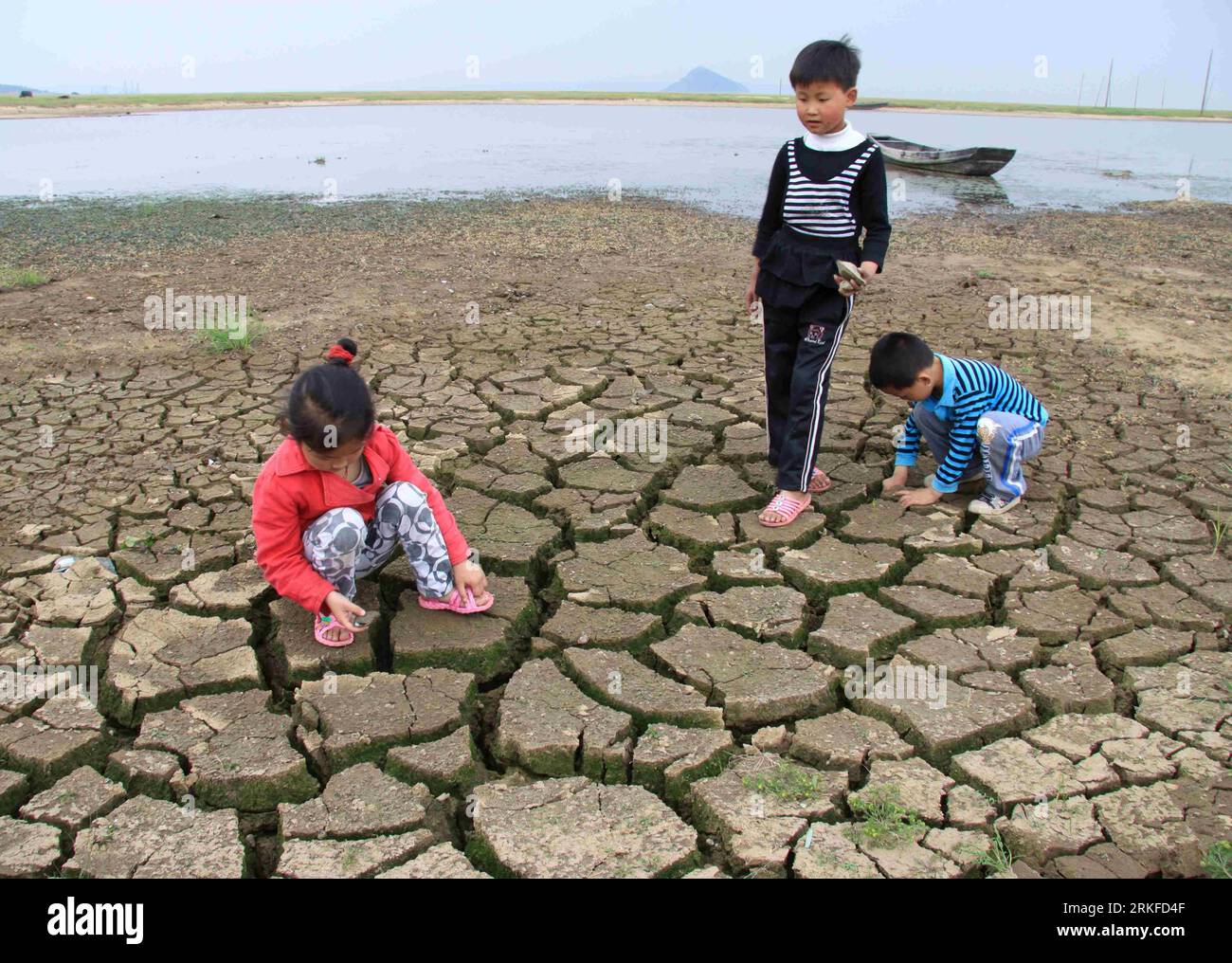 Bildnummer: 55402220  Datum: 26.05.2011  Copyright: imago/Xinhua (110526) -- JIUJIANG, May 26, 2011 (Xinhua) -- Children pick shells on the bed of Poyang Lake, east China s Jiangxi Province, May 25, 2011. Severe drought lingered at the Poyang Lake area despite several rainfalls in Jiangxi Province recently. (Xinhua/Yang Fan) (zgp) CHINA-JIANGXI-POYANG LAKE-DROUGHT (CN) PUBLICATIONxNOTxINxCHN Gesellschaft Dürre Trockenheit trocken Trockenperiode Dürreperiode Erde vertrocknet trocken kbdig xdp 2011 quer  o0 Dürre See Trockenheit Austrocknung ausgetrocknet  Kinder Risse Boden rissig    Bildnummer Stock Photo