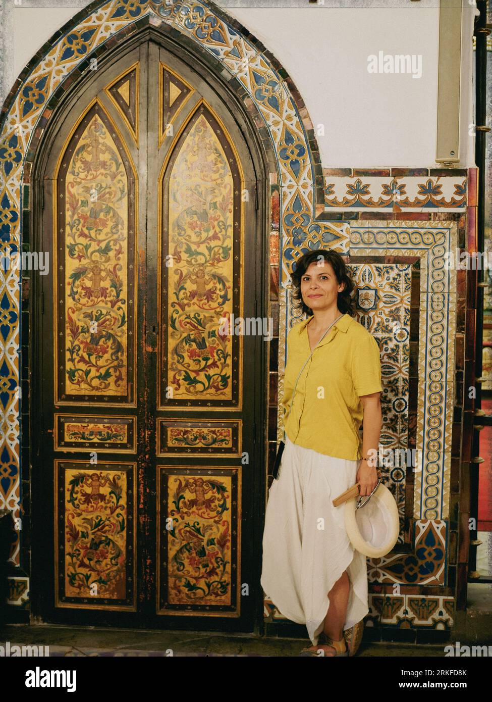 Visitor in front of a pointed arch door of the Epístola nave of the San Pedro Apostol parish, exquisitely decorated with Mudejar motifs. Stock Photo