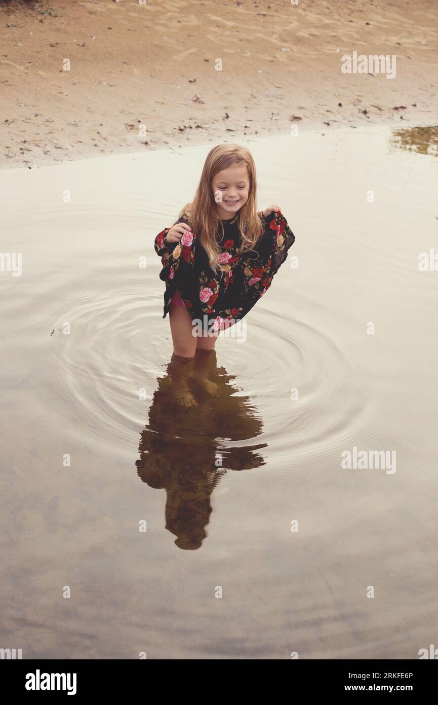 Girl plays in the lake in the morning light Stock Photo