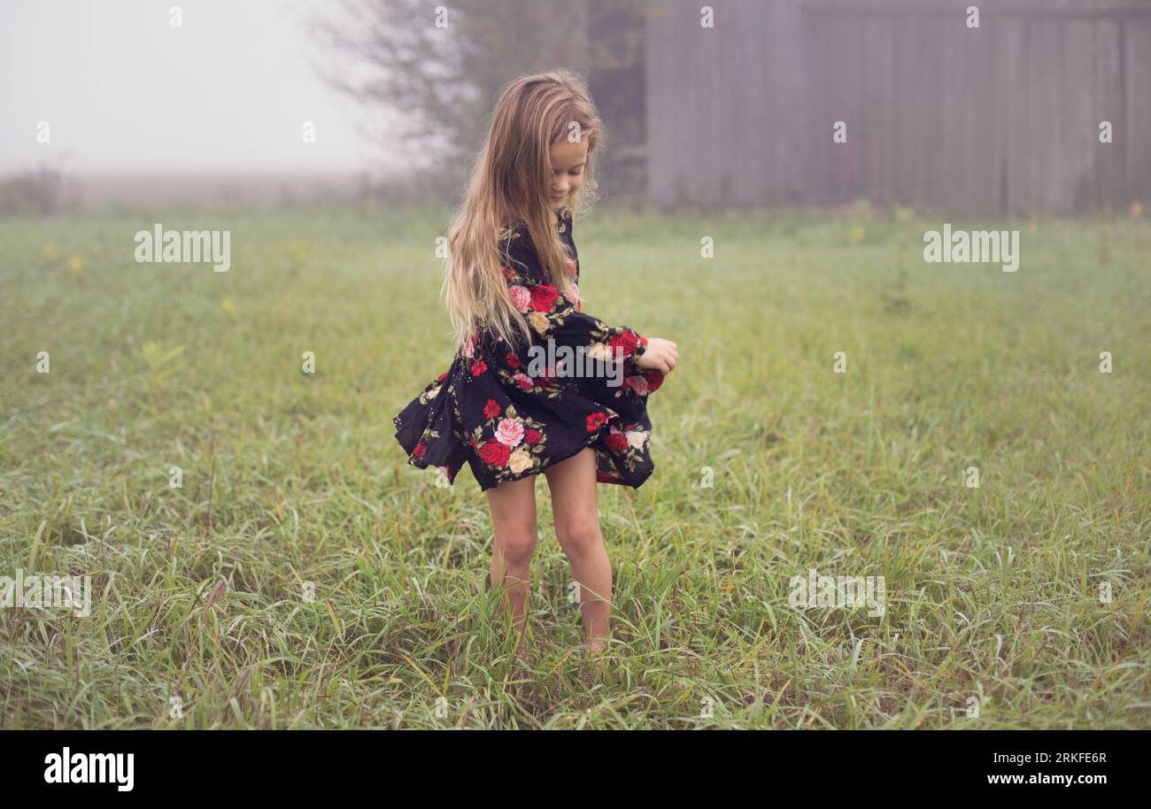 Young girl gracefully dances alone in the morning fog Stock Photo