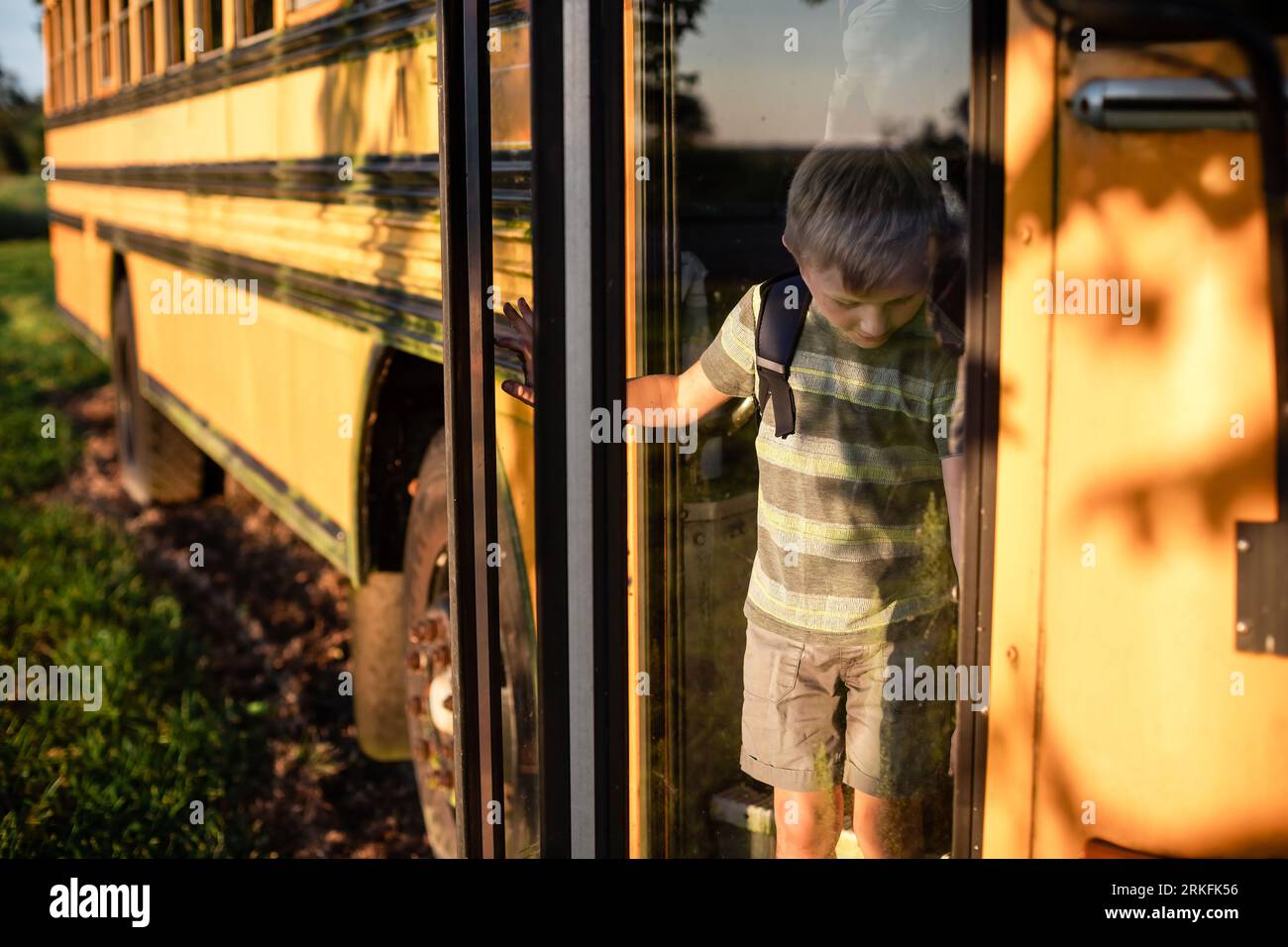 Child getting off the bus at bus stop after school Stock Photo