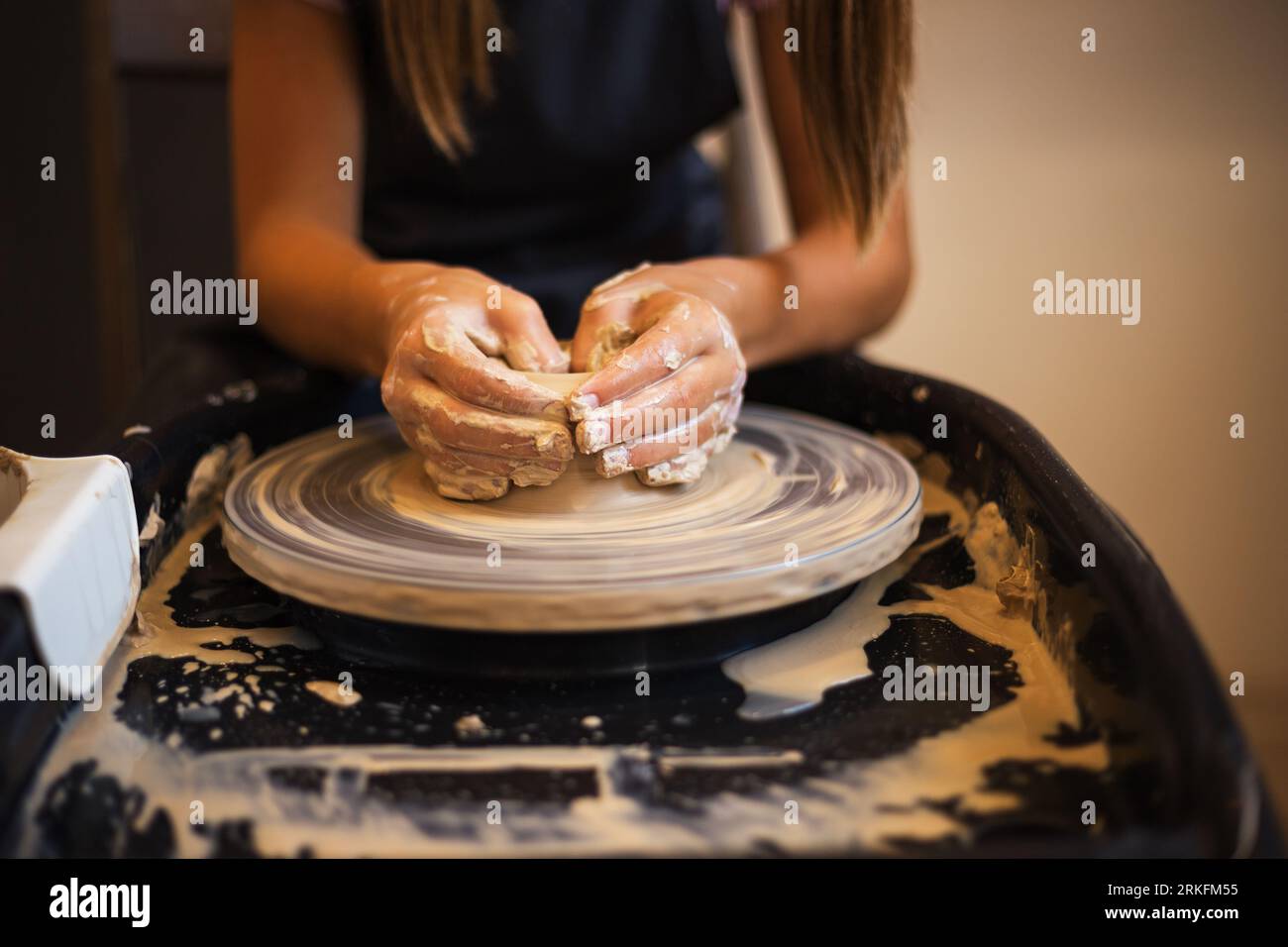 Hands of girl creating bowl on a Potter's wheel close up. Tradit Stock Photo