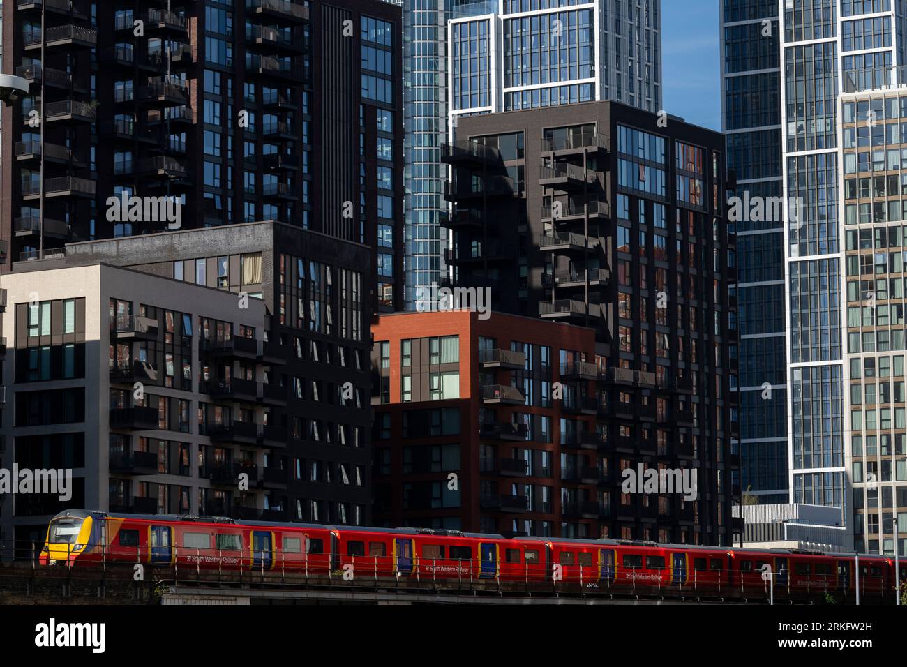 A train from Southwest Railways passing by newly constructed tower blocks in Nine Elms, South London. The tower blocks are part of a larger redevelopm Stock Photo