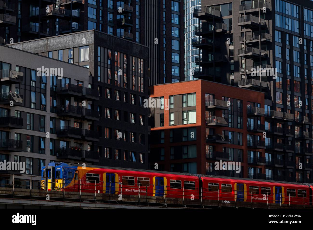 A train from Southwest Railways passing by newly constructed tower blocks in Nine Elms, South London. The tower blocks are part of a larger redevelopm Stock Photo