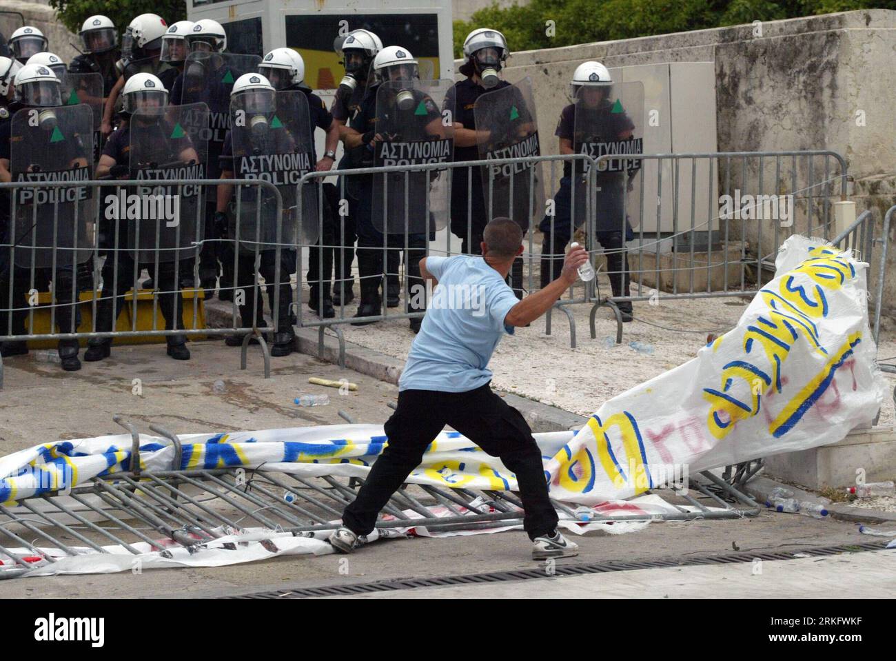 Bildnummer: 55460679  Datum: 15.06.2011  Copyright: imago/Xinhua (110615) -- ATHENS, June 15, 2011 (Xinhua) -- A demonstrator throws a bottle at anti-riot policemen at the Constitution Square in Athens, Greece, June 15, 2011. A new 24-hour nationwide general strike hit Greece Wednesday in protest at further austerity measures planned by the Greek government to counter its acute debt crisis. (Xinhua/Marios Lolos) (wjd) GREECE-AUSTERITY MEASURES-PROTEST PUBLICATIONxNOTxINxCHN Politik Proteste GRE x0x xkg 2011 quer     Bildnummer 55460679 Date 15 06 2011 Copyright Imago XINHUA  Athens June 15 201 Stock Photo