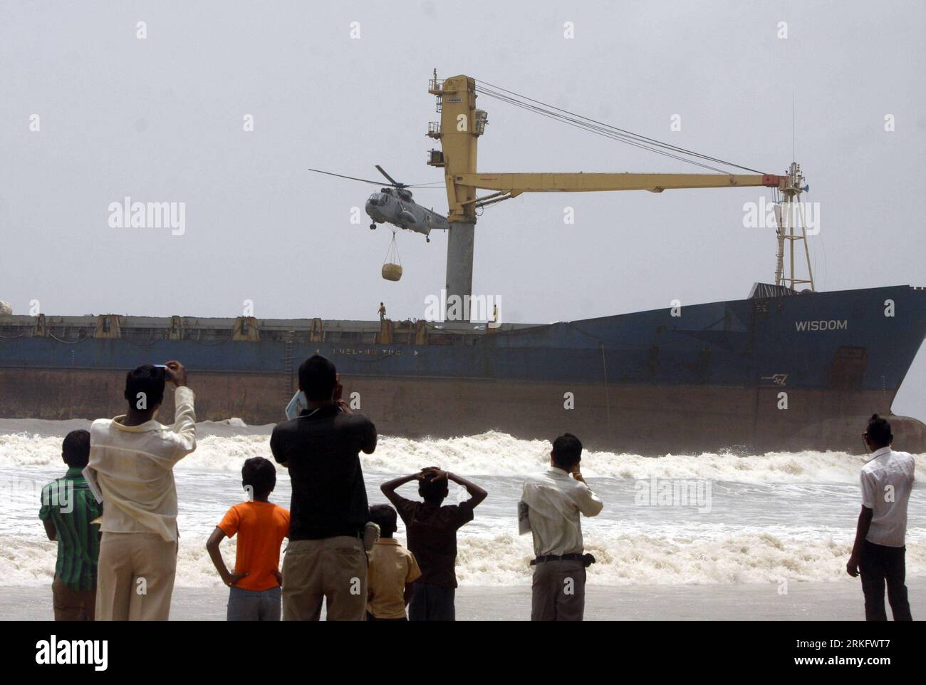 Bildnummer: 55463581  Datum: 16.06.2011  Copyright: imago/Xinhua (110616) -- MUMBAI, June 16, 2011 (Xinhua) -- An Indian Navy helicopter prepares to drop a bundle of metal cables onto the deck of a merchant ship which ran aground at Chowpatty Beach in Mumbai, India, June 16, 2011. The ship named Wisdom, which was being tugged to the Alang scrapyard in Gujarat from Colombo, broke away due to rough weather and drifted its way on to the Mumbai coast line. (Xinhua/Stringer) (ybg) INDIA-MUMBAI-SHIP PUBLICATIONxNOTxINxCHN Gesellschaft xub 2011 quer  o0 Schiff, Schifffahrt, Verkehr, Frachtschiff, Hav Stock Photo