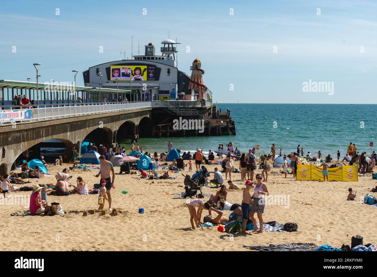Bournemouth, UK - August 22nd 2023: Sunbathers on the West Beach alongside Bournemouth Pier. Stock Photo