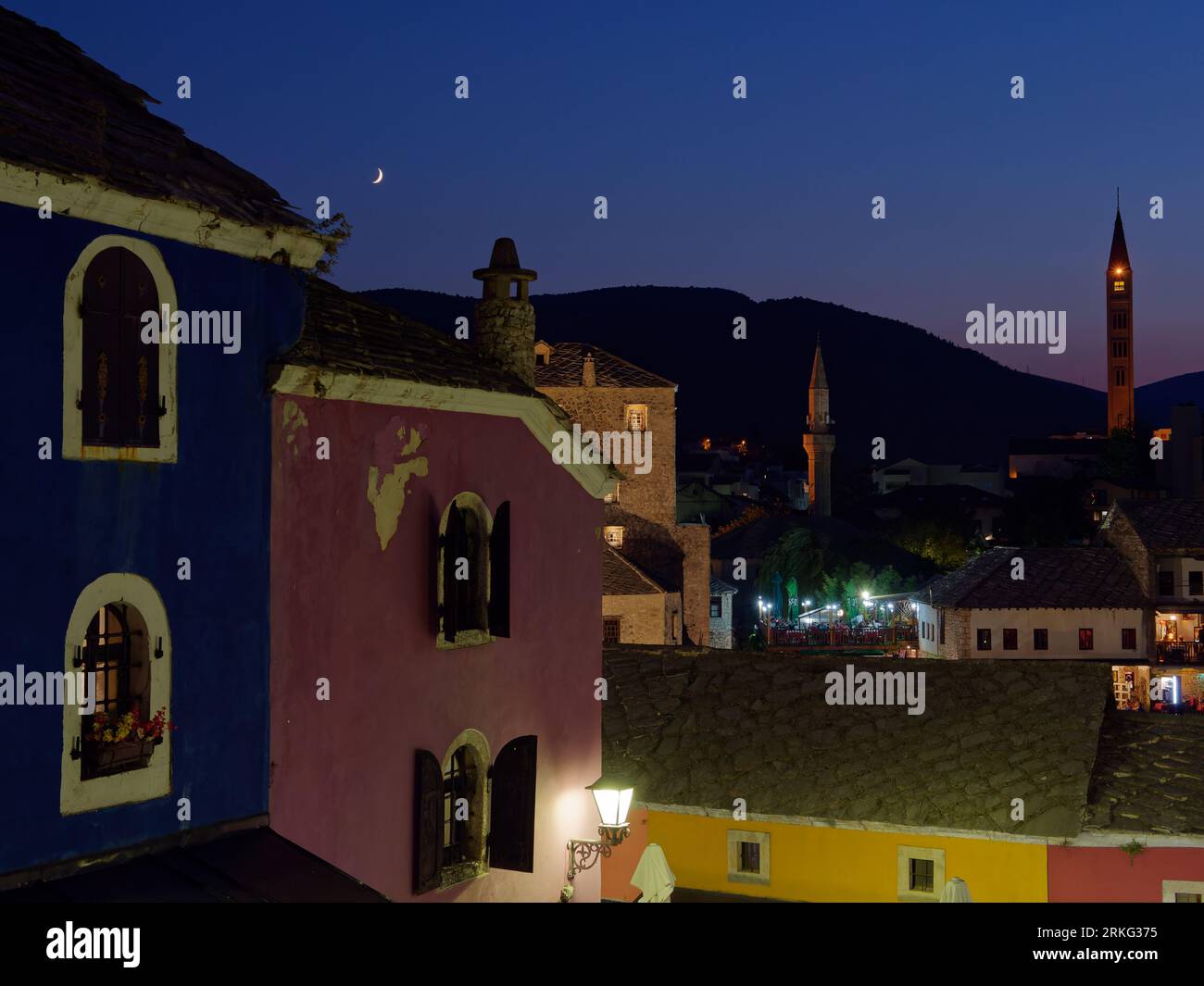 Colourful buildings on a in the old town of the city of Mostar on a summers night with mountain behind, Bosnia and Herzegovina, August 20, 2023. Stock Photo