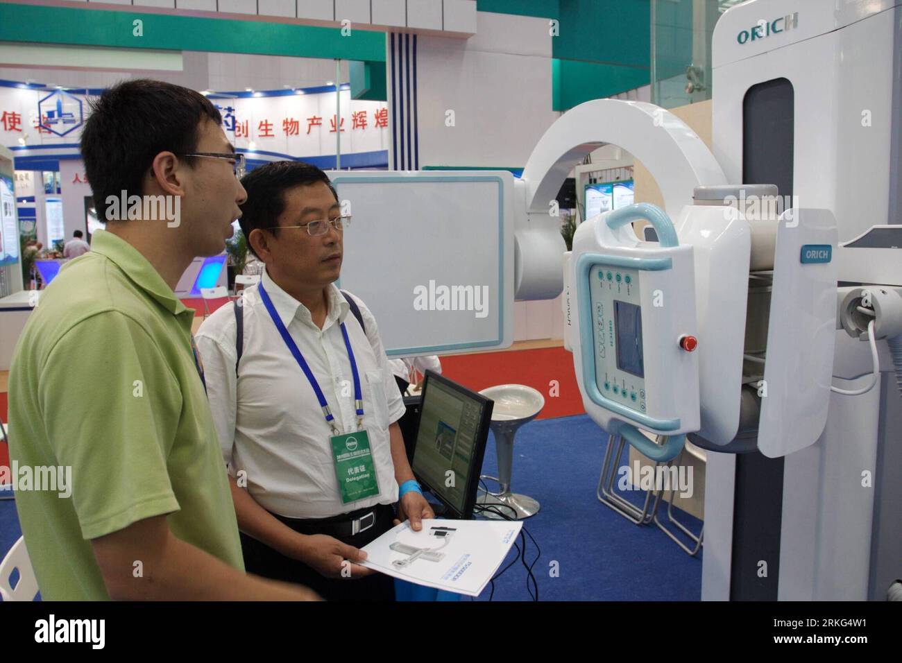 Bildnummer: 55546208  Datum: 26.06.2011  Copyright: imago/Xinhua (110626) -- TIANJIN, June 26, 2011 (Xinhua) -- A company staff (L) briefs a client about a direct digital radiography (DDR) machine, which applies digital X-ray technology, at the BioEco 2011 exhibition held in north China s Tianjin, June 26, 2011. The 4th International Conference for Bioeconomy (BioEco 2011), China s top bioeconomy forum, opened in Tianjin at the Meijiang Conference and Exhibition Center on Sunday. Some 222 Chinese and foreign companies have participated in the 3-day conference, showcasing over 1,000 biotechnolo Stock Photo