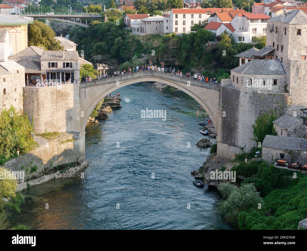 People sightseeing from Stari Most (Old Bridge) over the Neretva River in Mostar, Bosnia and Herzegovina, August 22, 2023. Stock Photo