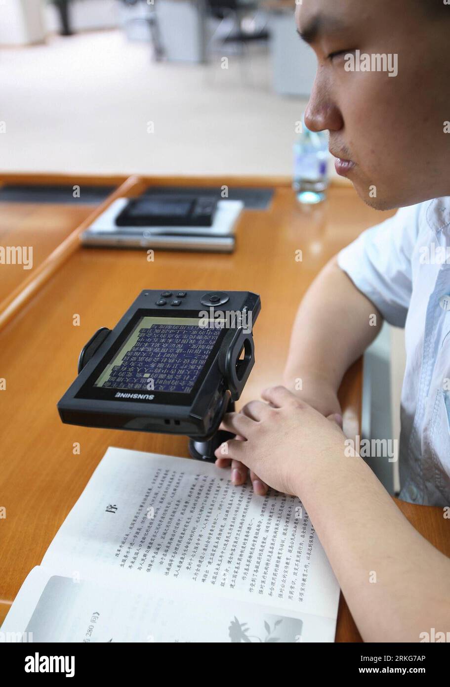Bildnummer: 55560215  Datum: 30.06.2011  Copyright: imago/Xinhua (110630) -- BEIJING, June 30, 2011 (Xinhua) -- A visually impaired man reads a book by a special reading device that contains a scanner and a speaker at the Chinese National Library for the Blind in Beijing, China, June 30, 2011. The Beijing-based Chinese National Library for the Blind opened a new location on Tuesday. The new location has 28,000 square meters and is divided into many sections that include training and exhibition areas. The new library boasts a collection of over 50,000 Braille books, large-lettered books and aud Stock Photo