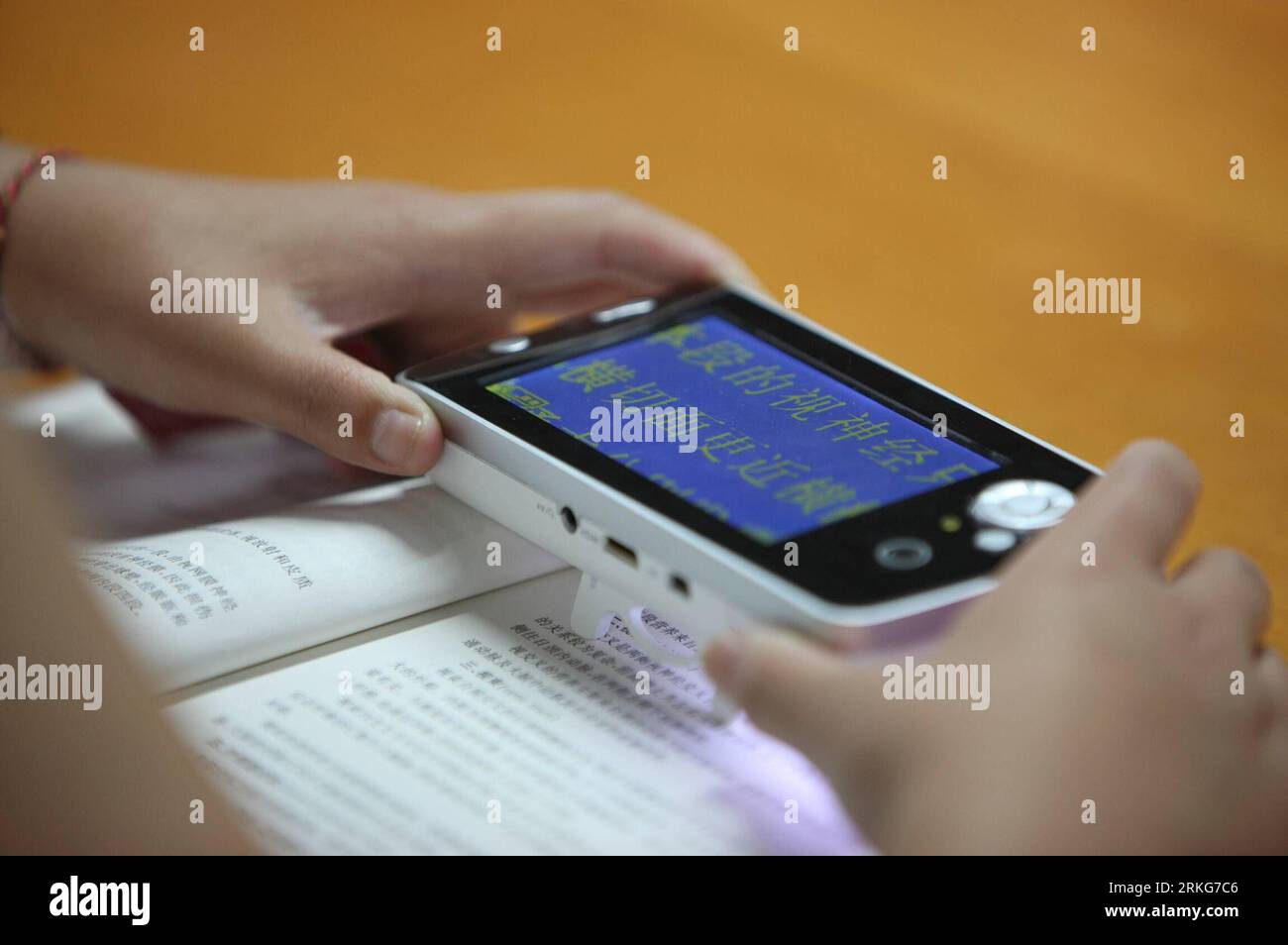 Bildnummer: 55560209  Datum: 30.06.2011  Copyright: imago/Xinhua (110630) -- BEIJING, June 30, 2011 (Xinhua) -- A visually impaired person reads a book under the help of a device capable of magnifying characters of the text, at the Chinese National Library for the Blind in Beijing, China, June 30, 2011. The Beijing-based Chinese National Library for the Blind opened a new location on Tuesday. The new location has 28,000 square meters and is divided into many sections that include training and exhibition areas. The new library boasts a collection of over 50,000 Braille books, large-lettered boo Stock Photo