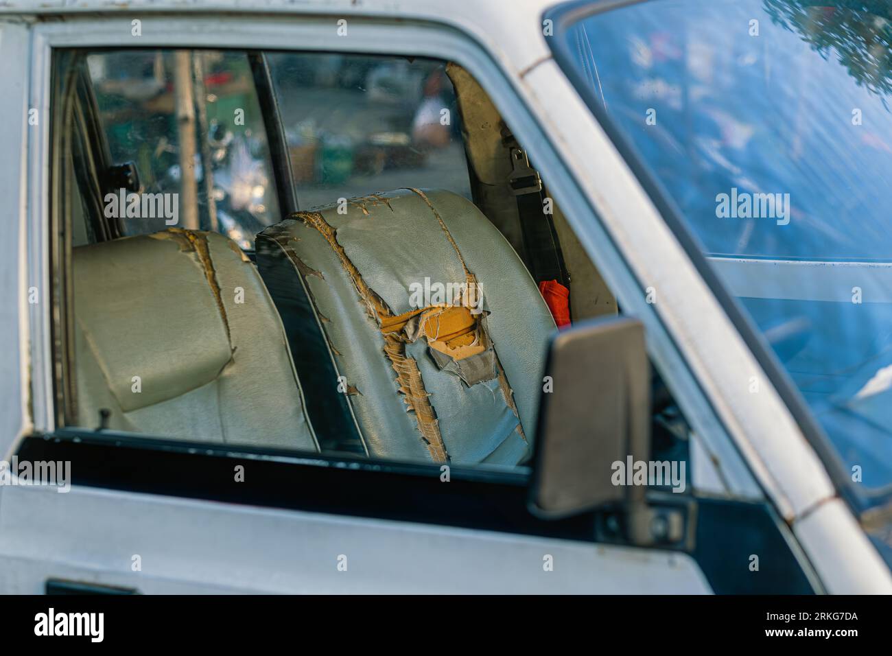 Old dirty car seat beige color of perforated leather with cracks and