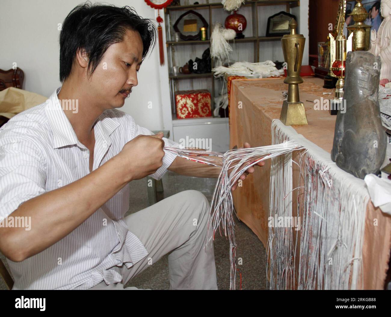 Bildnummer: 55574403  Datum: 06.07.2011  Copyright: imago/Xinhua (110706) -- QUANZHOU, July 6, 2011 (Xinhua) -- An artist works on a paper texture painting in Yongchun County, southeast China s Fujian Province, July 6, 2011. The art of paper texture painting in Yongchun dates back to some 1000 years ago. In order to create an unique effect of the paper texture painting, the artist has to tailor a paper painting into strips which are 2 millimeters wide with a special knife, interweave them with blank paper strips and color the overall artwork. (Xinhua/Yan Caibin) (zhs) #CHINA-FUJIAN-YONGCHUN-PA Stock Photo