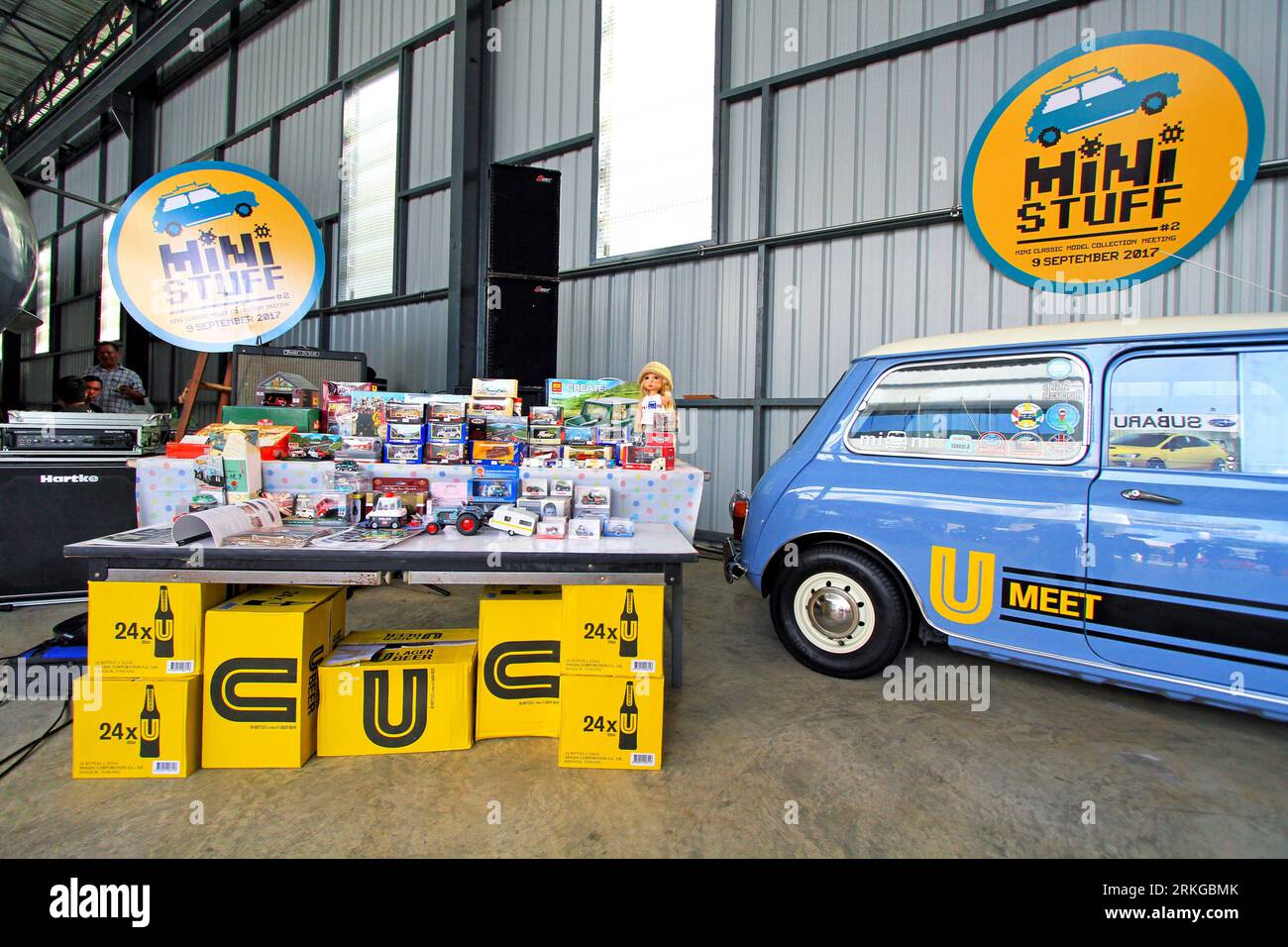 A classic blue Mini Austin parked in a garage filled with a plethora of toys Stock Photo