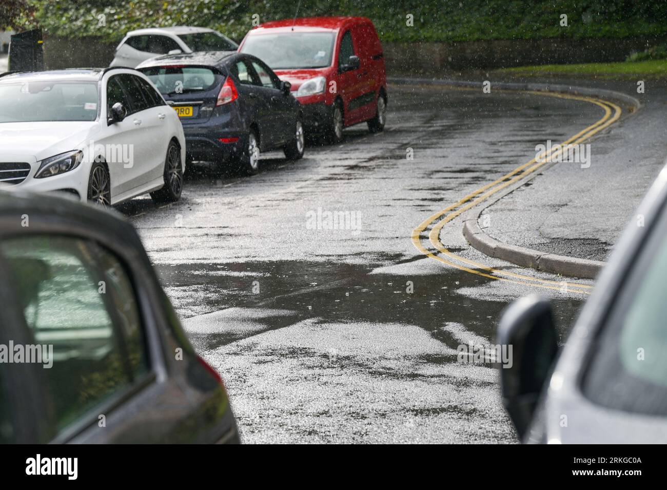 Summer rain raindrops during storm in urban street with parked cars ...