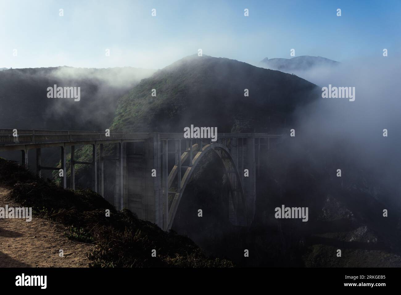 The majestic, fog-shrouded Bixby Creek Bridge arcs across the breathtaking mountainscape Stock Photo