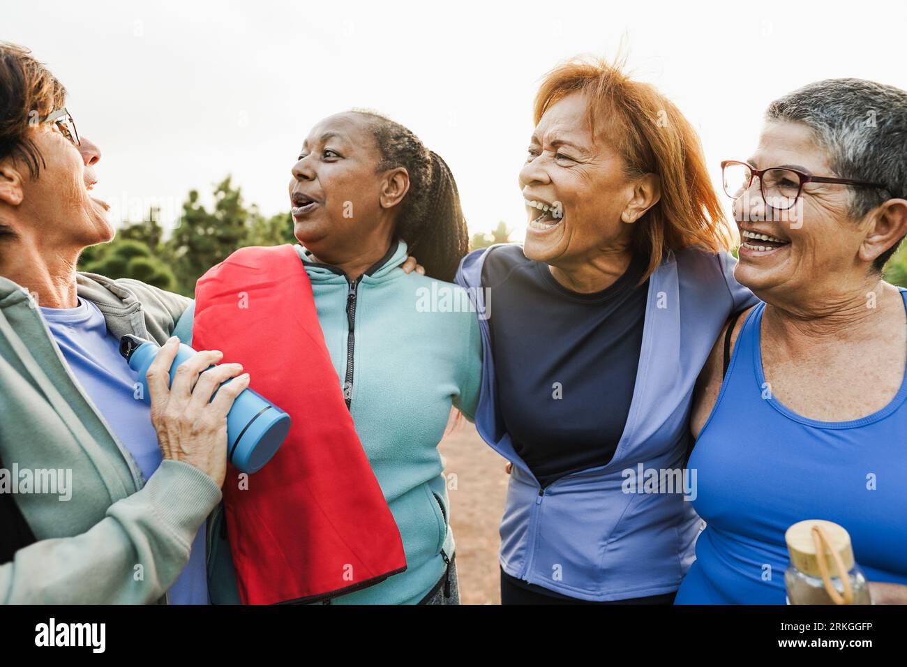 Happy senior women having fun laughing together after yoga class outdoor at city park - Sport and healthy lifestyle concept Stock Photo