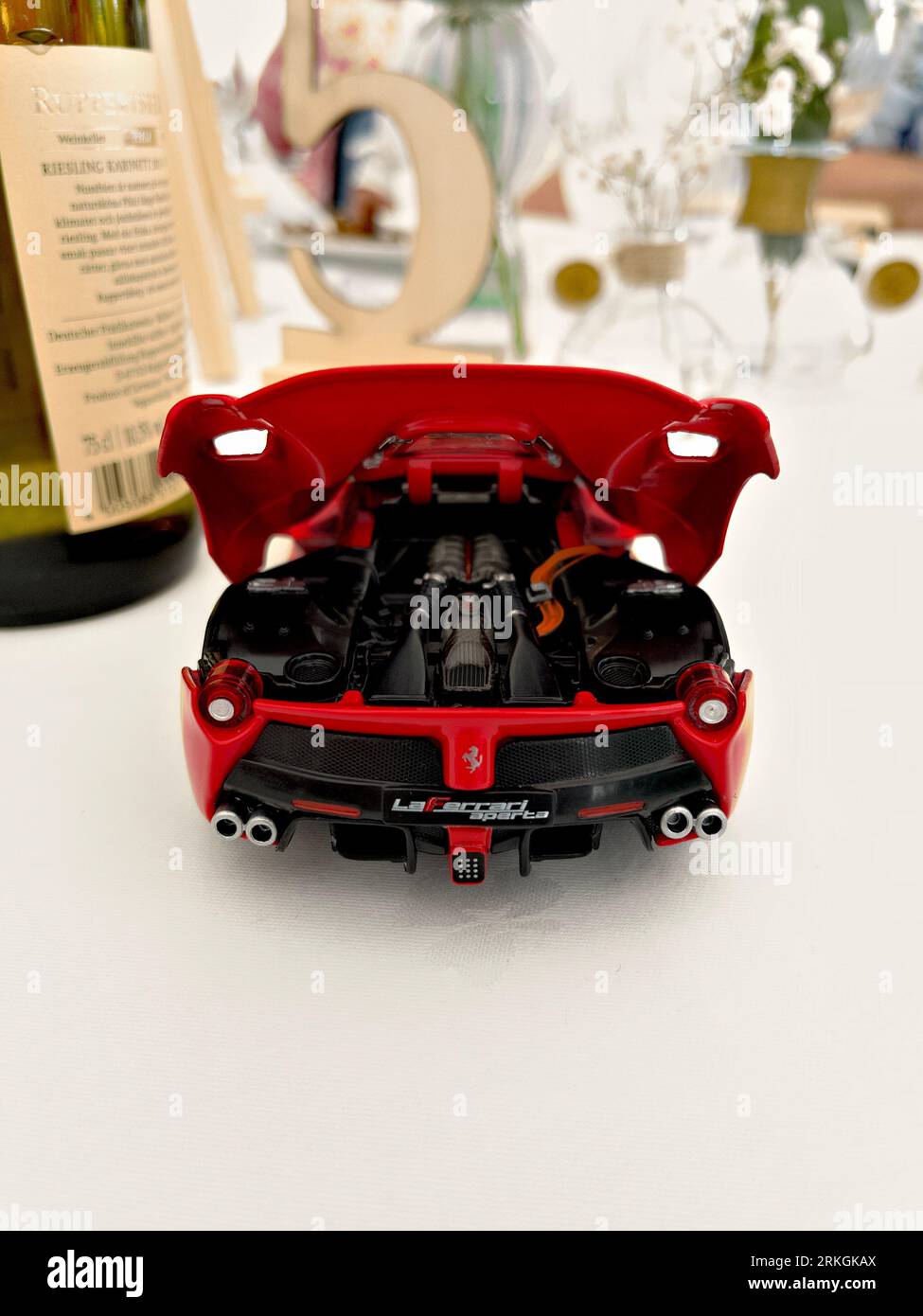 A vertical of a miniature red Ferrari model car on a table Stock Photo
