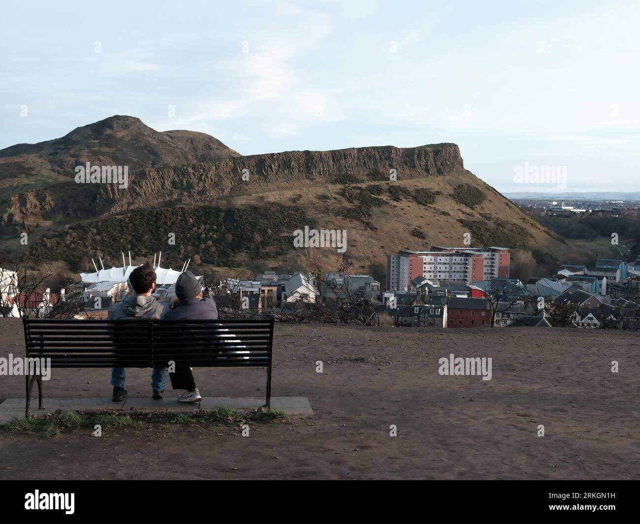 A young couple enjoying a romantic moment on a park bench while ...