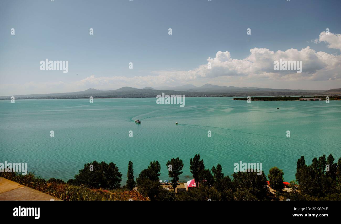 An aerial view of a stunning blue lake surrounded by lush greenery ...