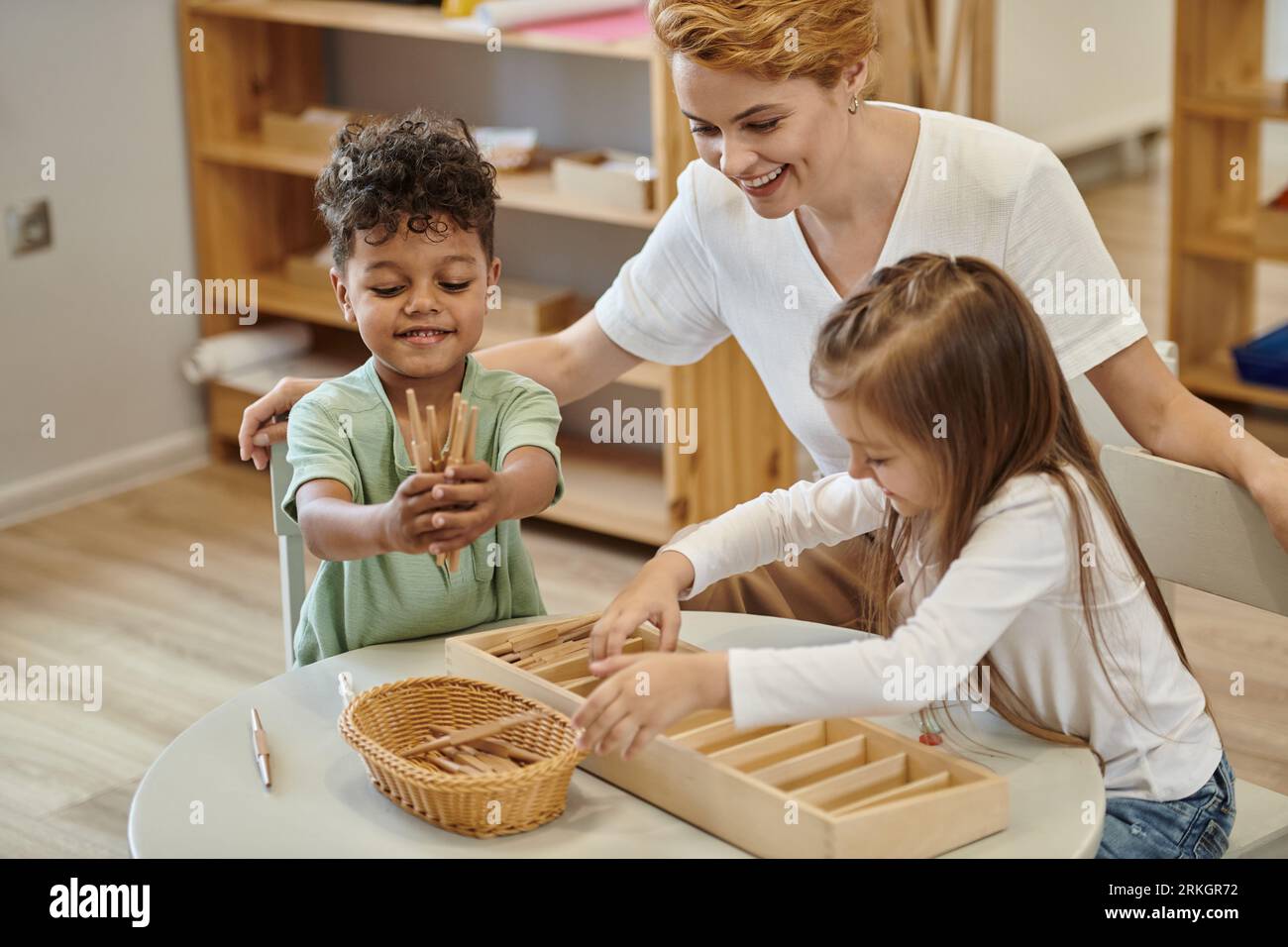 positive multiethnic kids playing with wooden didactic materials near