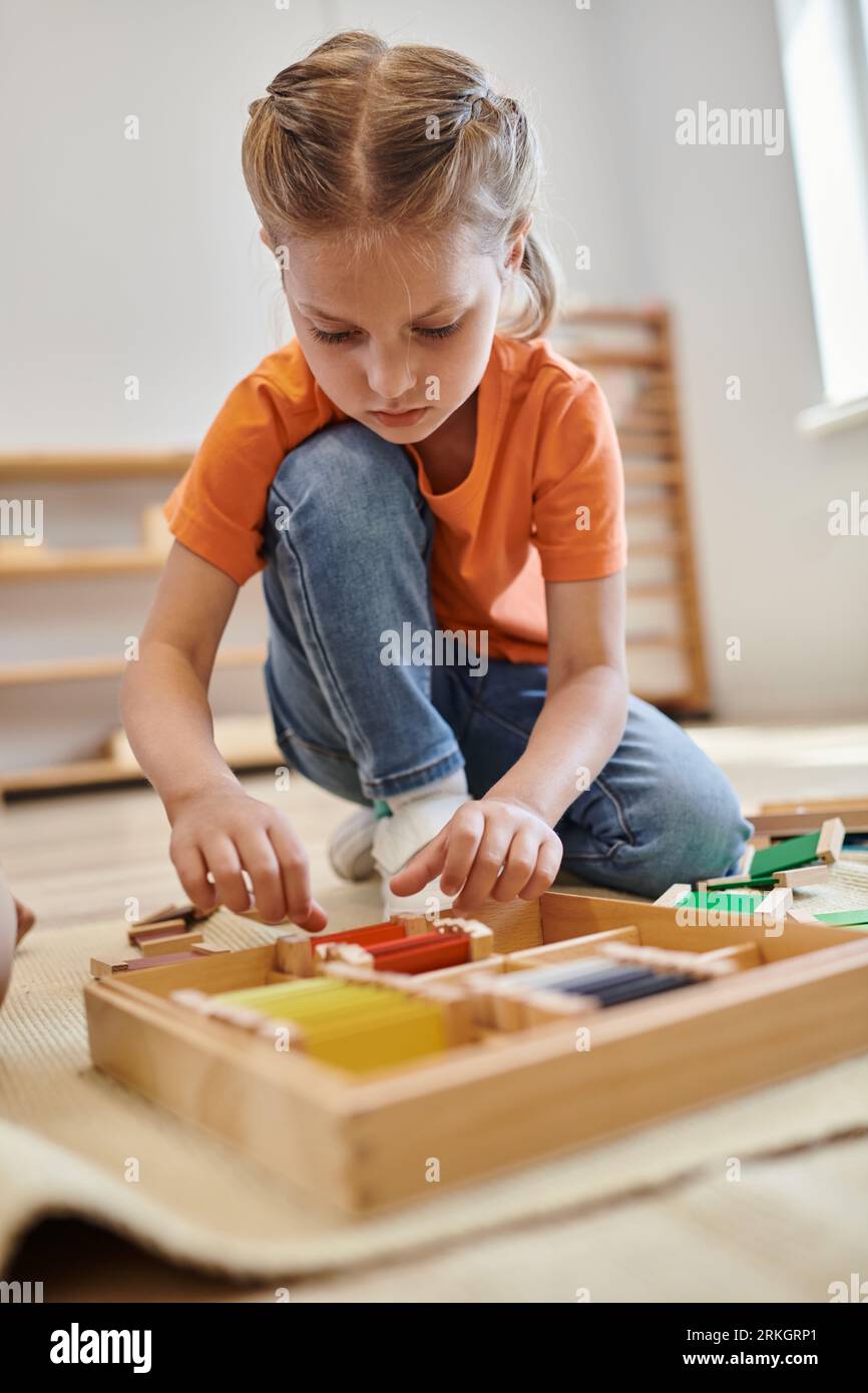 montessori school concept, girl playing color matching game and sitting