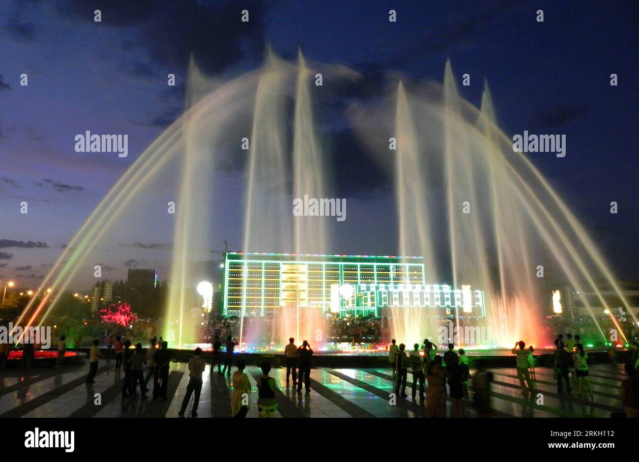 Bildnummer: 55674024  Datum: 01.08.2011  Copyright: imago/Xinhua (110802) -- HOHHOT, August 2, 2011 (Xinhua) -- Residents cool off themselves beside a music fountain at Ruyi Square in Hohhot, capital of north China s Inner Mongolia Autonomous Region, August 1, 2011. A heat wave swept here with the highest temperature topping 33 degree celsius in recent days. (Xinhua/Li Yunping) (zl) CHINA-INNER MONGOLIA-HEAT WAVE (CN) PUBLICATIONxNOTxINxCHN Reisen CHN xns 2011 quer o0 Brunnen, Wasserspiele, Beleuchtung, Restlicht, Abend, Dämmerung, Abenddämmerung, Totale    Bildnummer 55674024 Date 01 08 2011 Stock Photo