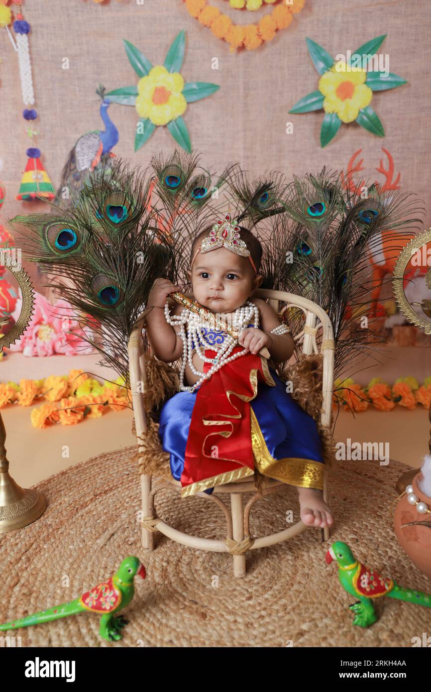 Janmashtami Concept. Cute baby boy dressed up as little krishna sitting