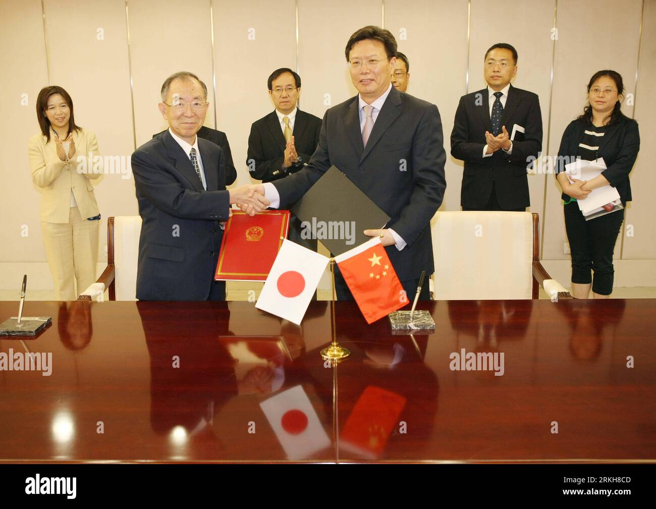 Bildnummer: 55715249  Datum: 12.08.2011  Copyright: imago/Xinhua (110812) -- BEIJING, Aug. 12, 2011 (Xinhua) -- Yu Jianhua (R, front), China s assistant minister of commerce, and Japanese ambassador to China Uichiro Niwa (L, front) shake hands after signing a scholarship aid agreement in Beijing, capital of China, Aug. 12, 2011. According to the agreement, the Japanese government will provide 383 million yen (4.86 million U.S. dollars) in aid to finance the study of 35 Chinese civil servants in Japan, the Chinese Ministry of Commerce (MOC) said Friday. (Xinhua/Li Fangyu) (llp) CHINA-BEIJING-JA Stock Photo