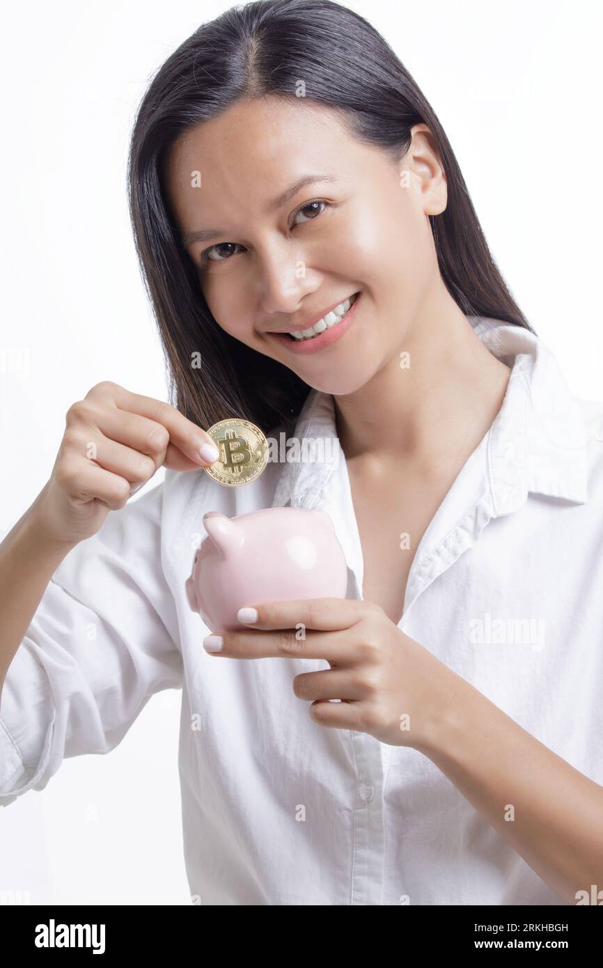 Asian American Woman saving Bitcoin into a piggy bank isolated on a white  background with copy space Stock Photo - Alamy