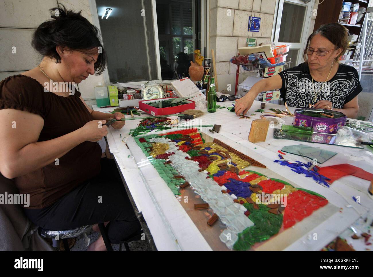 Bildnummer: 55807663  Datum: 20.08.2011  Copyright: imago/Xinhua (110820) -- WEST BANK, Aug. 20, 2011 (Xinhua) -- Samia Rishmawi(L) and her sister Faten work on a broken glass mosaic at their glass workshop in the West Bank city of Bethlehem, Aug. 18, 2011. The three Palestinian sisters Samia, Sawsan and Faten Rishmawi started their work ten years ago, making beautiful galss images with pieces of colored broken glass. (Xinhua/Luay Sababa) (srb) MIDEAST-WEST BANK-BROKEN GLASS-MOSAIC PUBLICATIONxNOTxINxCHN Gesellschaft Glas Mosaik Herstellung Glasmosaik Arbeitswelten Das letzte Abendmahl xdf x0x Stock Photo