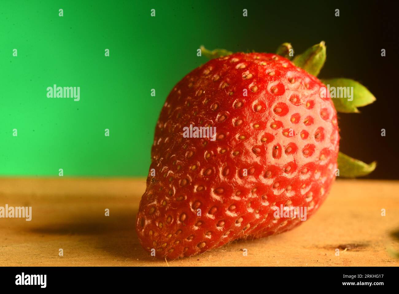 Strawberry fruit close up on studio shot, green background Stock Photo ...
